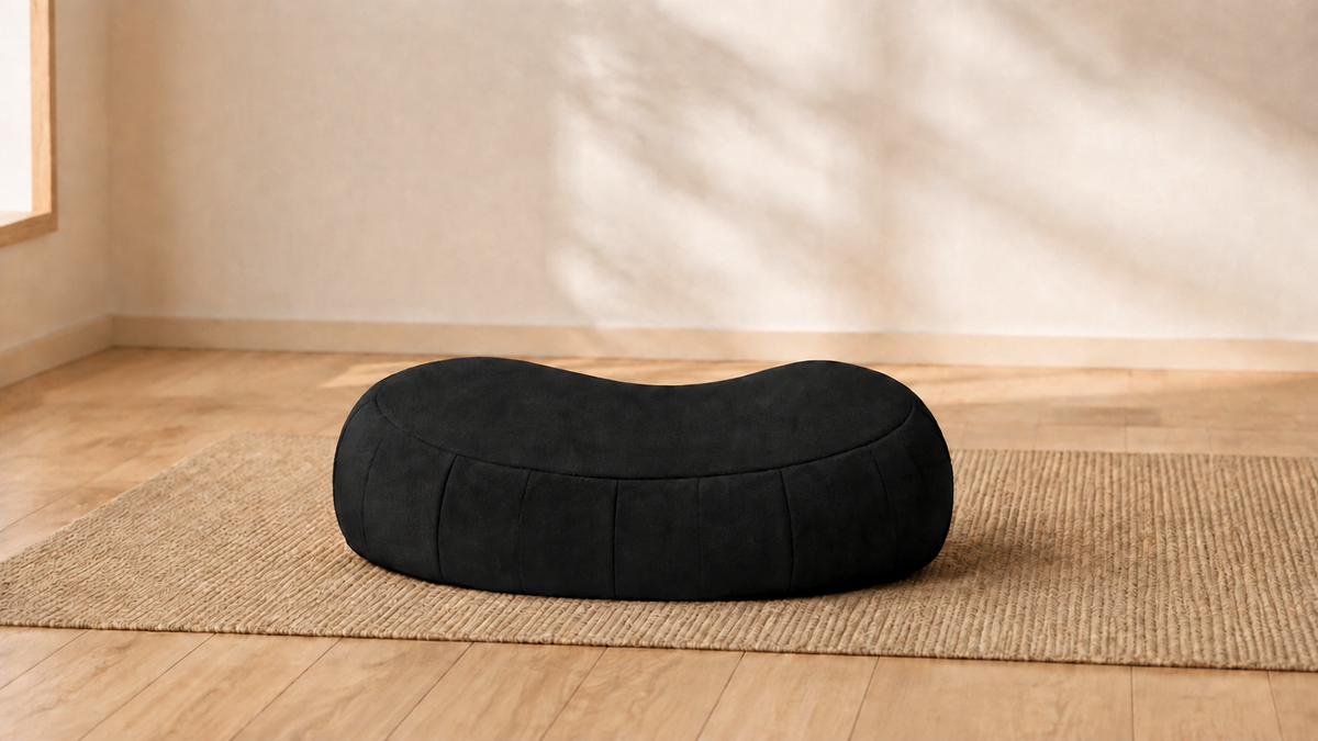 Black meditation cushion in a calm, minimal meditation room
