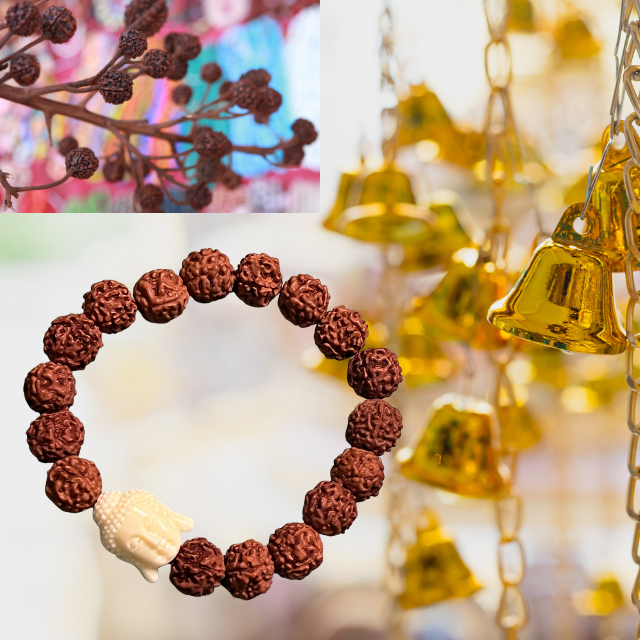 A Snazzy Jahzzie LLC 9mm Buddha Vajra Bodhi Rudraksha Bracelet made of round, textured beads with a single bead shaped like a Buddha head is centered in the image. Behind it, blurred golden bells hang from chains, evoking a sense of meditation. In the top left corner, there is a blurry image of brown, round flowers.