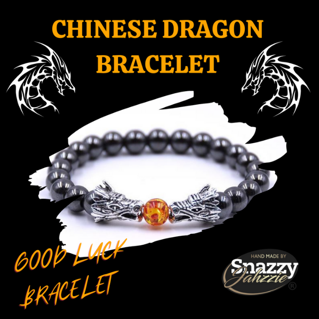 A bracelet with 8mm Hematite beads and a central orange bead flanked by two silver dragon heads. The background is black with stylized dragon graphics and text that reads "CHINESE HEMATITE DRAGON BRACELET 8mm" and "GOOD LUCK BRACELET." The logo "Snazzy Jahzzie LLC" is at the bottom.